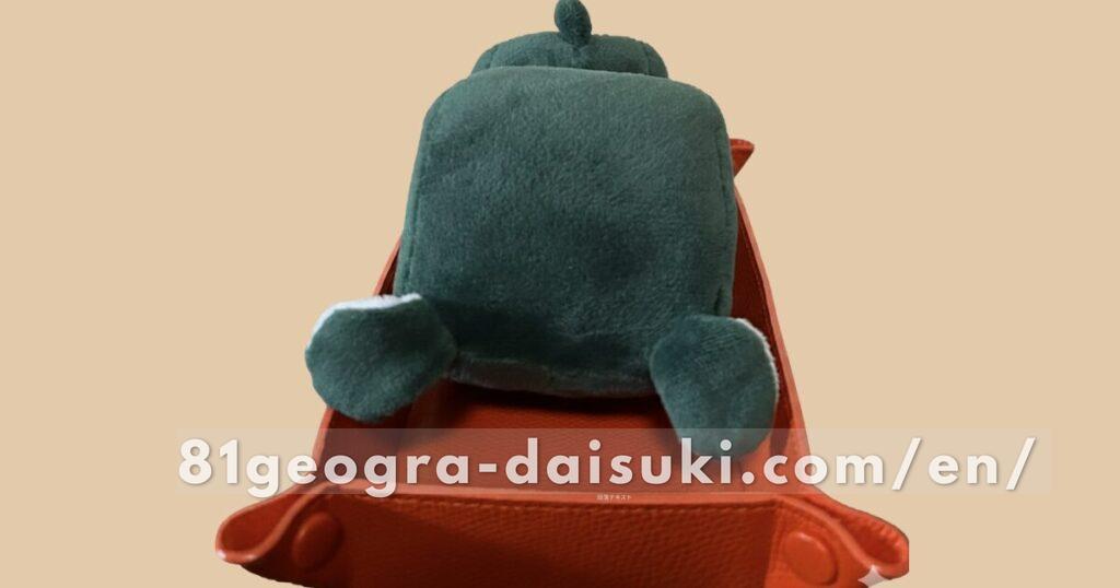 Delimaru plushie fallen over on his face on a tray because he cannot balance himself.