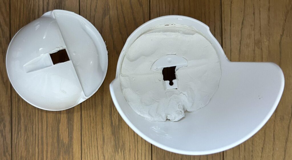 Inside of a white spherical smartphone holder from Daiso, cut in half and filled with white paper clay for weight.