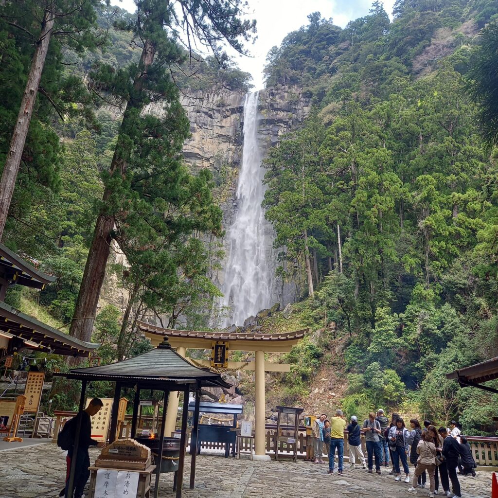 Torii gate of Hiryu Shrine with Nachi Falls towering behind