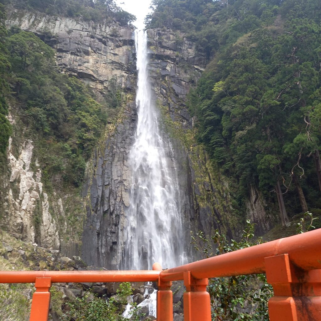 Nachi Falls viewed from the worship stage at Hiryu Shrine, with red railings in the foreground