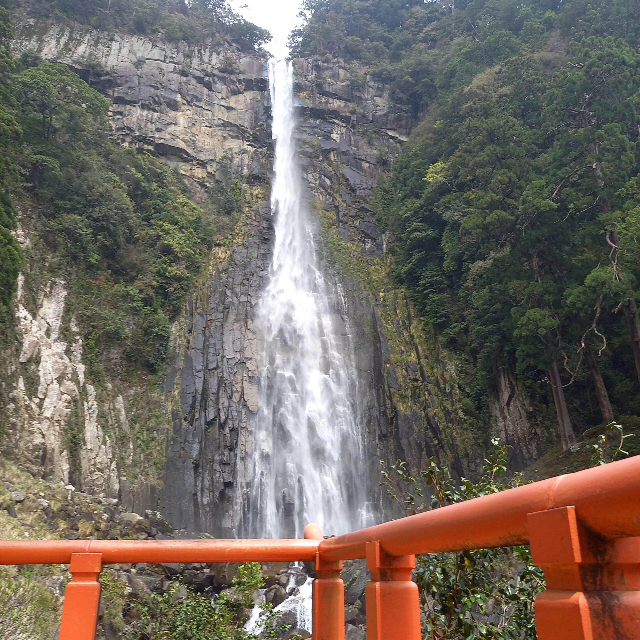 Nachi Falls viewed from the worship stage at Hiryu Shrine, with red railings in the foreground