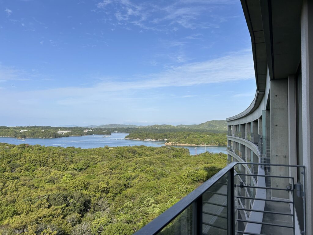 "Ago Bay view from a guest room balcony at The Bay Suite, Shima Kanko Hotel, with the building's curved facade stretching alongside