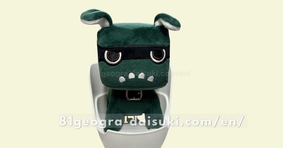 Delimaru plushie sitting upright on a white smartphone holder from Daiso.