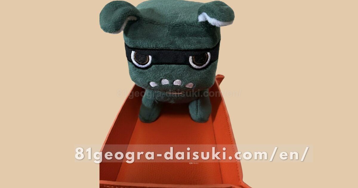 Delimaru plushie barely standing on its own on an accessory tray, looking a bit unstable.