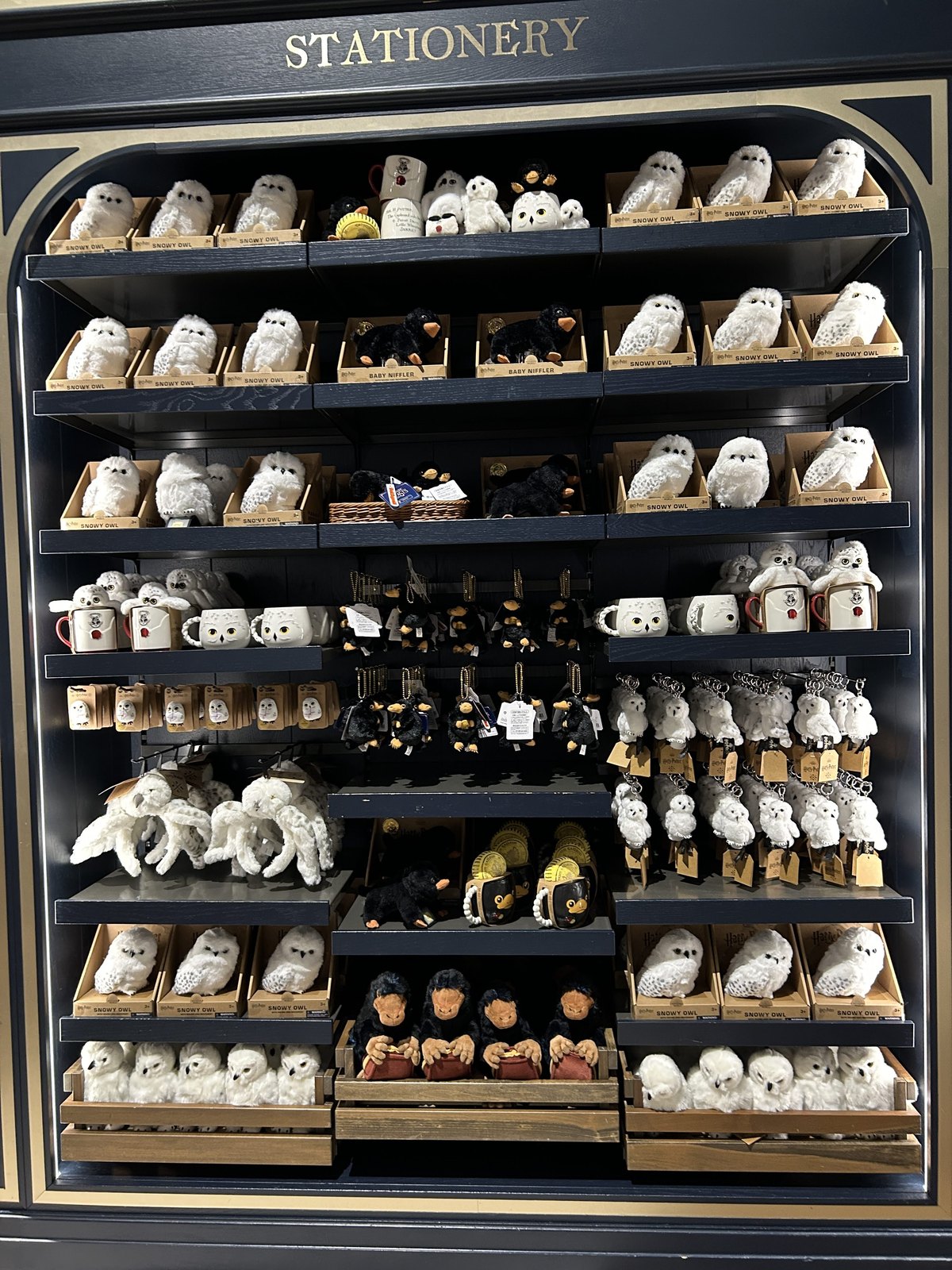 Niffler and snowy owl plush toys, mugs and key rings in the stationery area