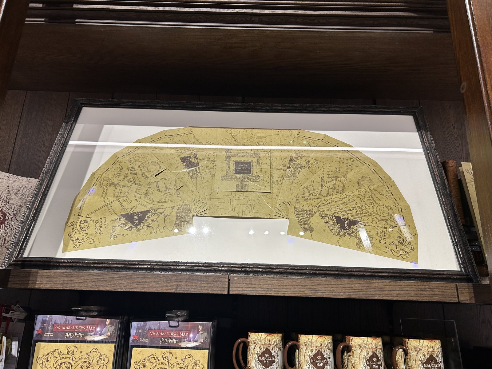 Large framed Marauder's Map with mugs displayed below it